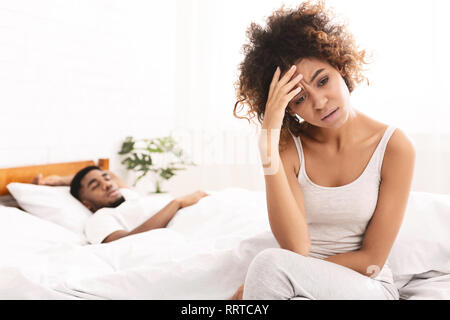 Unglücklich schwarze Frau leidet unter Kopfschmerzen, im Bett sitzen Stockfoto