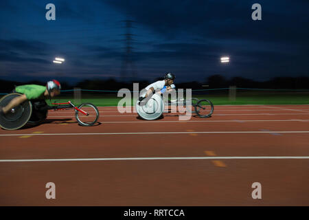 Querschnittsgelähmte Sportler Beschleunigung zusammen Sport Track im Rollstuhl Rennen Stockfoto