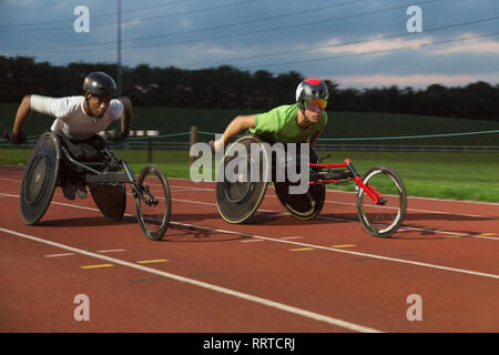 Querschnittsgelähmte Sportler Beschleunigung zusammen Sport Track im Rollstuhl Rennen Stockfoto