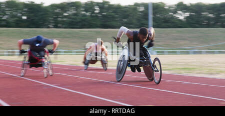 Querschnittsgelähmte Sportler Beschleunigung zusammen Sport Track im Rollstuhl Rennen Stockfoto