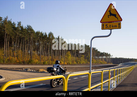 Ein Schild warnt Motorradfahrer, dass es eine Rehe oder andere Wildtiere Überqueren der Straße vor Stockfoto