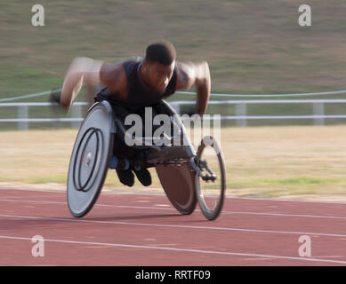 Bestimmt jungen männlichen querschnittsgelähmten Athlet Beschleunigung zusammen Sport Spur während der Rollstuhl Rennen Stockfoto