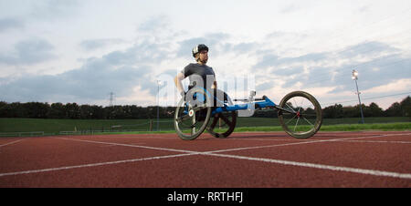 Junge weibliche paraplegic Athlet Training für Rollstuhl Rennen auf Sport Track bestimmt Stockfoto