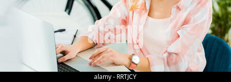 7/8-Ansicht der Frau in der armbanduhr Tippen auf Laptop Tastatur Stockfoto