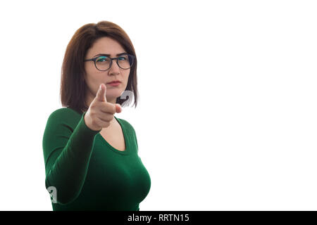 Wütende junge Frau zeigt mit dem Zeigefinger auf die Kamera, wie jemand schimpfen, auf weißem Hintergrund mit Kopie Raum isoliert. Stockfoto