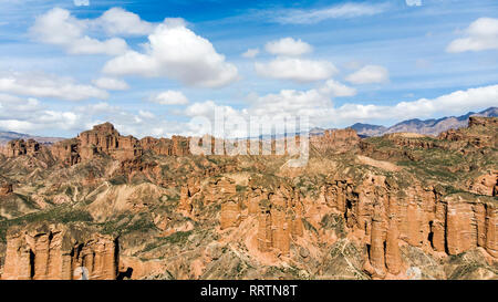 Luftaufnahme von Binggou Danxia Canyon Relief in Zhangye, Sunan Region, Provinz Gansu, China. Rote Sandsteinfelsen im Geopark. Niedrige Wolken und Blau Stockfoto