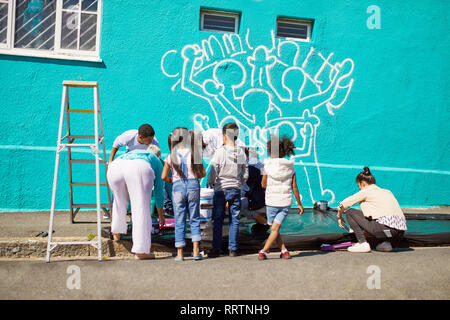 Kid freiwillige Malerei Gemeinschaft Wandbild an sonnigen Wand Stockfoto