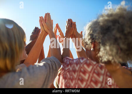 Gruppe mit gefalteten Händen im Kreis während des Yoga Retreat Stockfoto
