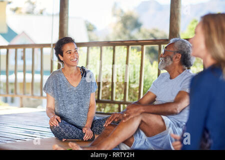 Lächelnd Mann und Frau sprechen in der Hütte während Yoga Retreat Stockfoto