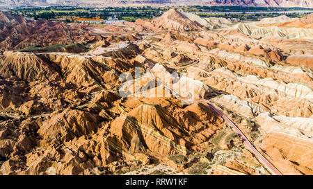 Blick von oben auf die Rainbow Bergen geologischen Park. Stripy Zhangye Danxia Relief geologischen Park in der Provinz Gansu, China. Drone Bild von Touristenbussen Stockfoto