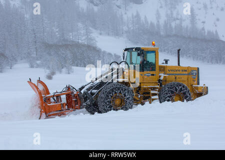 Frankreich, Bessans - Februar 1, 2019: Schneepflug rechen Schnee während der Schnee in den Bergen Stockfoto