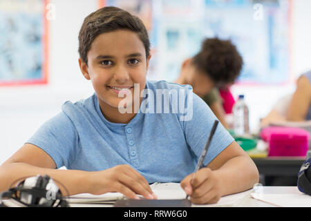 Portrait zuversichtlich Junior high school junge Schüler Hausaufgaben im Unterricht Stockfoto