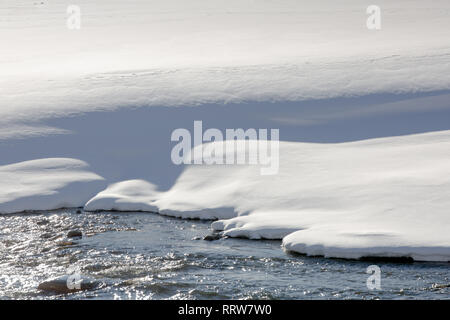 Berge, Schnee, Fluss. Nahaufnahme eines schneebedeckten Bank von einem Berg River. Selektiver Fokus Stockfoto