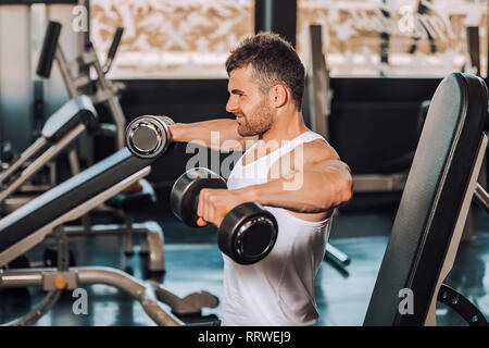 Muskulöse mann Training mit Hanteln in Fitnessstudio - Bild bestimmt Stockfoto