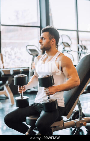 Muskulöse mann Training mit Hanteln in Fitnessstudio - Bild bestimmt Stockfoto