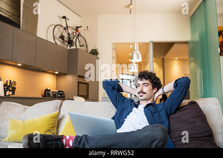 Mann entspannt auf Apartment Sofa Stockfoto
