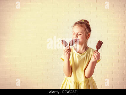 Gerne kleine Mädchen essen Popsicle im Sommer Platz kopieren Stockfoto
