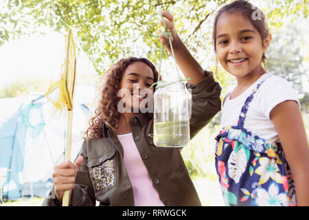 Portrait happy Schwestern Fisch im Glas fangen Stockfoto