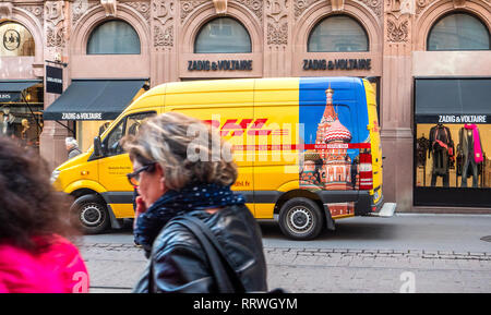 Straßburg, Frankreich - 26.Oktober 2018: Fußgänger vor der DHL Deutsche Post gelben Lieferwagen auf der Straße geparkt in Frankreich vor der Luxus mode kleidung store Zadig und Voltaire Stockfoto