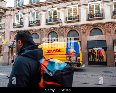 Straßburg, Frankreich - 26.Oktober 2018: die Menschen vor der DHL Deutsche Post gelben Lieferwagen auf der Straße geparkt in Frankreich vor der Luxus mode kleidung store Zadig und Voltaire - Moskau Aufkleber auf der Van Stockfoto