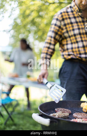 Man grillen Hamburger vom Grill Stockfoto