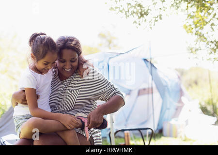 Mutter, Tochter auf Schuhe für Camping setzen Stockfoto