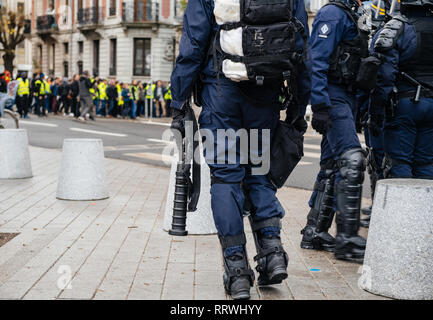 Ansicht der Rückseite des Polizisten sichern die Zone vor dem Gelben Westen Bewegung die Demonstranten auf Quai des Bateliers Straße Detail auf der Pistolen, Gewehren, Baton, gas Pistolen und zerreißen, Stockfoto