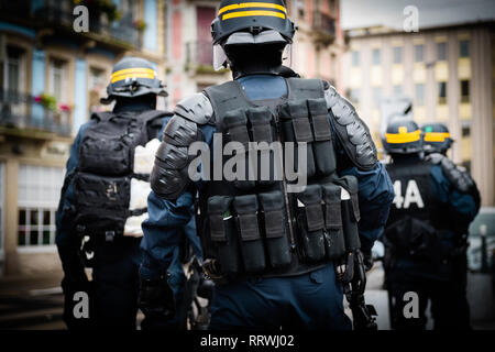 Ansicht der Rückseite des Polizisten sichern die Zone vor dem Gelben Westen Bewegung die Demonstranten auf Quai des Bateliers Straße Detail auf der Pistolen, Gewehren, Baton, gas Pistolen und zerreißen, Stockfoto