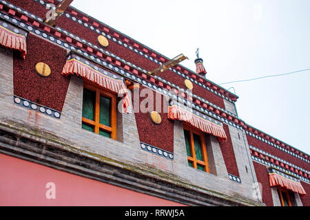 Bunte tibetischer Architektur. Detaillierte Fassade des obersten Etage des Traditionellen buddhistischen Gebäude. Rote chinesische Windows. Stockfoto