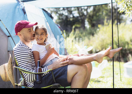 Glücklich, liebevoller Vater Holding Tochter in der Runde an sonnige Campingplatz Stockfoto