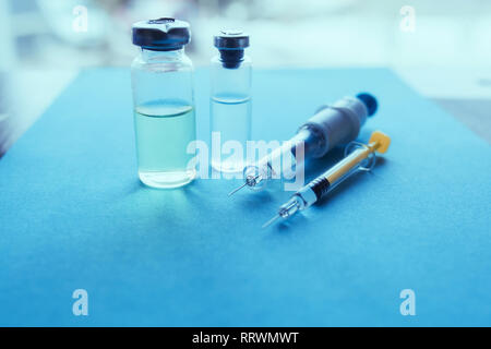 Spritzen, Medizin Flaschen auf einem blauen Hintergrund. Impfung Konzept Stockfoto
