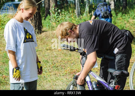 Vinzili, Russland - September 4, 2005: Velodanger den Wettbewerb im Hoheitsgebiet des Unfertigen psychiatrischen Klinik. Junger Mann Kontrolle Fahrrad von Mädchen. Tyume Stockfoto