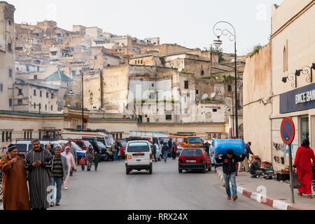 Verkehr und parkende Autos und Busse auf dem Boulevard Ben Mohammed El Alaoui mit der alten Medina von Fex im Hintergrund. Fez, Marokko. Stockfoto