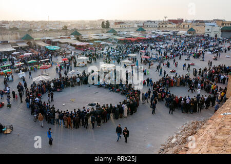 Massen von Menschen beobachten, Straßentheater in el Hedim Square während des Sonnenuntergangs. Meknes, Marokko. Stockfoto