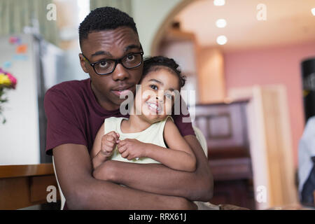 Portrait zärtlich teenage Bruder umarmen toddler Schwester Stockfoto