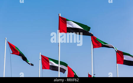 Viele Vereinigte Arabische Emirate flags Wicklung in der Wind gegen den blauen Himmel Stockfoto