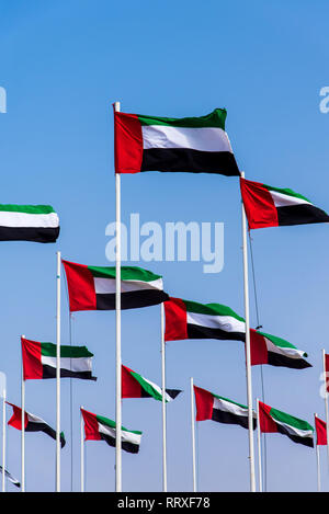 Viele Vereinigte Arabische Emirate flags Wicklung in der Wind gegen den blauen Himmel Stockfoto