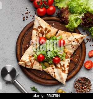 Sternförmige Pizza mit Salat und Tomaten eingerichtet Stockfoto