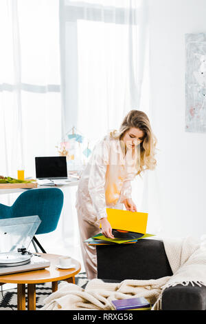 Attraktive junge Frau im Schlafanzug holding Schallplatte in Morgen Stockfoto