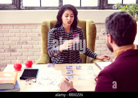 Schöne kluge Frau, die eine Karte auf Ihrem Client Stockfoto