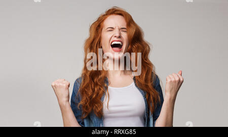 Junge rothaarige Frau schreiend mit Freude überglücklich Stockfoto