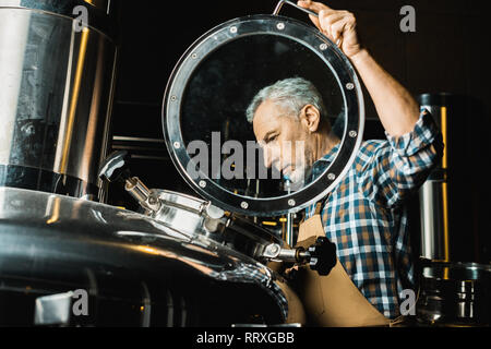 Professionelle männliche Brauer in Overalls Kontrolle Brauereianlagen Stockfoto