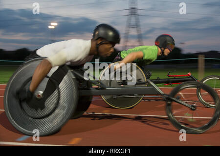 Querschnittsgelähmte Sportler Beschleunigung zusammen Sport Track im Rollstuhl Rennen Stockfoto