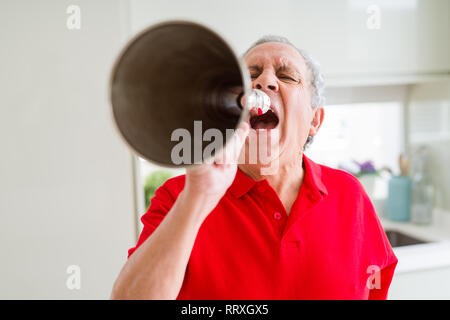 Älterer Mann shouthing durch vintage Metall Megaphon aufgeregt Stockfoto