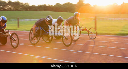 Bestimmt querschnittsgelähmte Sportler Beschleunigung zusammen Sport Track im Rollstuhl Rennen Stockfoto