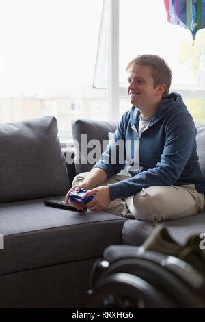 Lächelnden jungen Frau spielen Video Game auf dem Sofa Stockfoto