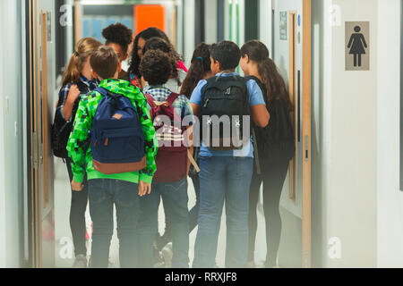 Junior high Studenten mit Rucksäcken zu Fuß in der Schule Korridor Stockfoto
