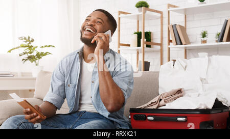 Glückliche Menschen Vorbereitung für Reisen, am Telefon sprechen Stockfoto