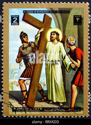 AJMAN - ca. 1973: einen Stempel in Ajman gedruckt zeigt Jesus nimmt das Kreuz, Kreuzweg, Ostern, ca. 1973 Stockfoto