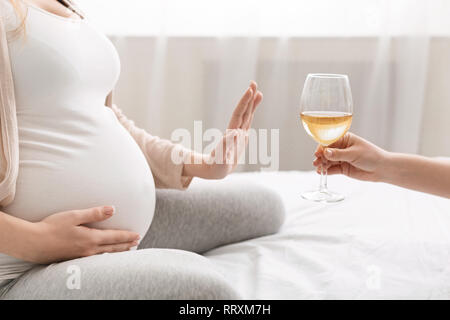 Junge schwangere Frau sich weigert, Wein zu trinken Stockfoto